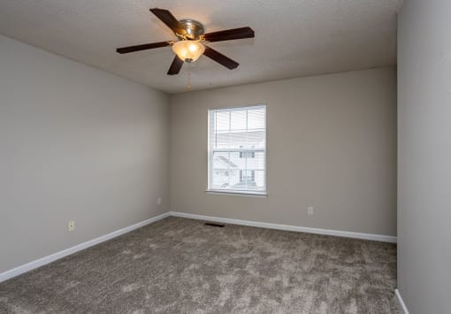 a bedroom with a ceiling fan and a window