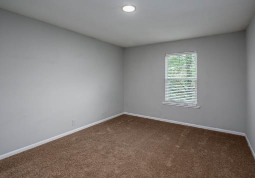 a bedroom with gray walls and a window