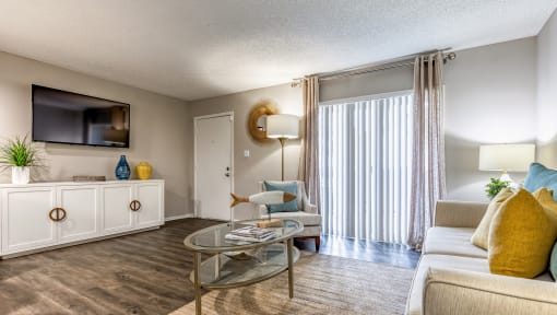 a living room with a couch and a table and a tv at L'Estancia, Sarasota, 34231