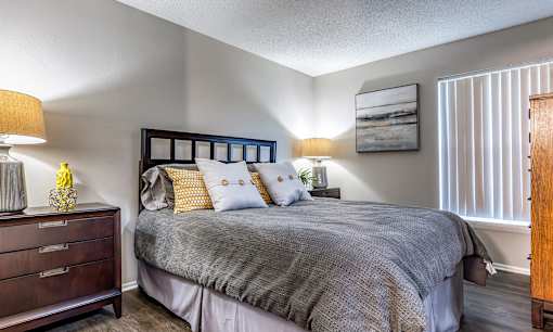 A bedroom with a bed, nightstand, and lamp L'Estancia, Sarasota, FL, 34231