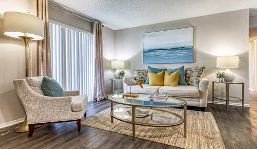 A living room with a beige chair, a white couch, and a glass coffee table L'Estancia, Sarasota, FL, 34231