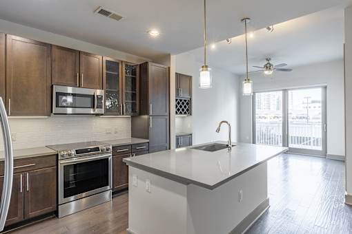 A modern kitchen with a large island and stainless steel appliances.