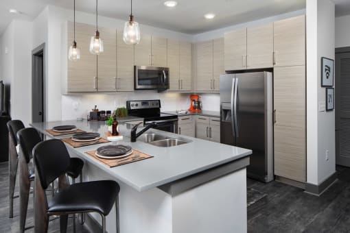 a kitchen with a large island and a stainless steel refrigerator
