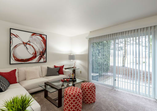a living room with a white couch and a glass coffee table in front of a sliding glass  at Pheasant Run, Saginaw, 48638