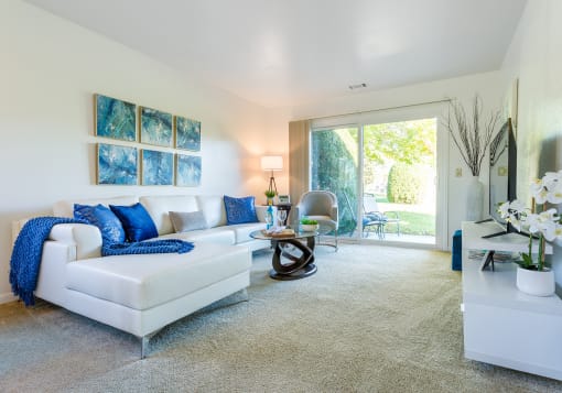 a living room with a white couch and blue pillows