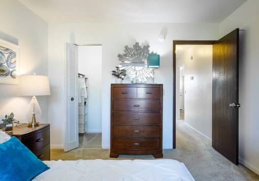a bedroom with a dresser and mirror