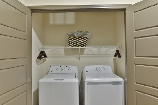 a white washer and dryer in a small laundry room