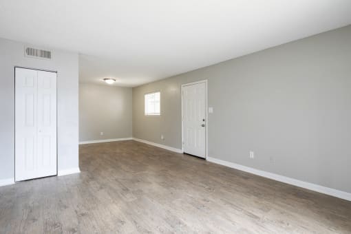 the living room and dining room of an empty home with wood flooring