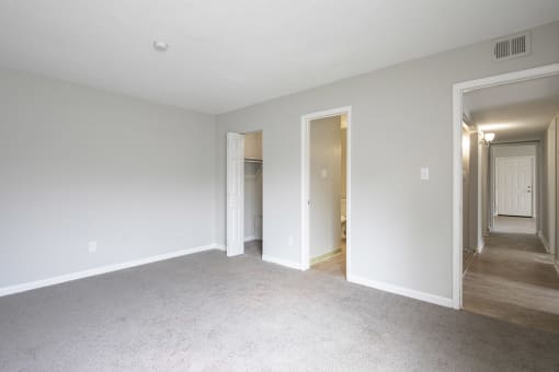 an empty living room and hallway with white walls and white carpet