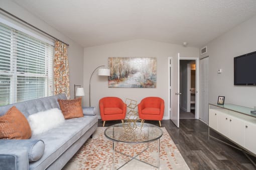 a living room with a couch and two chairs and a table