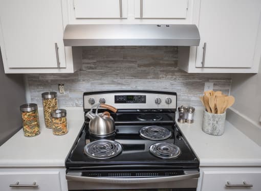 a small kitchen with a stove and a kettle on it