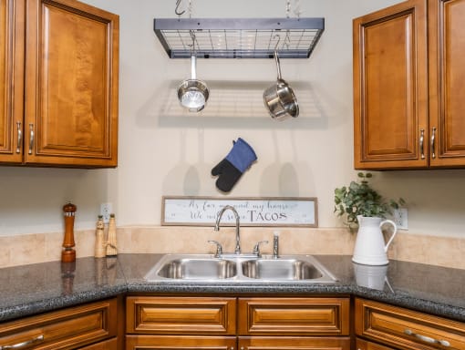 a kitchen with a sink and cabinets and a pot rack above it