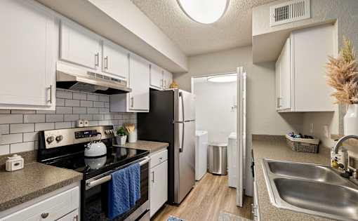 A kitchen with white cabinets and a black stove top oven.