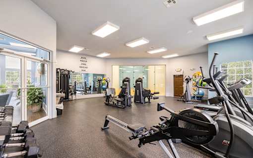 A gym with treadmills, elliptical machines, and other exercise equipment.