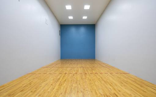 A room with wooden flooring and a blue wall.