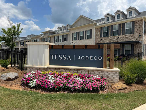 A sign that says Tessa Jodeco in front of a building.