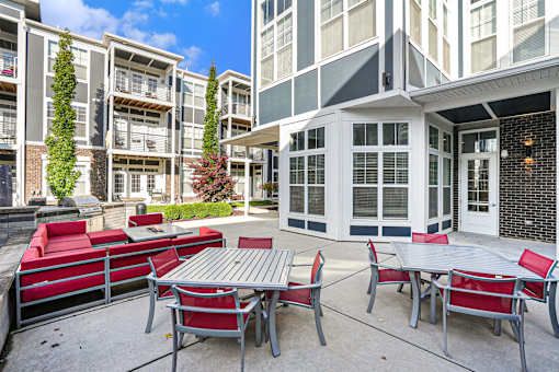 A patio with a table and chairs is surrounded by apartment buildings.