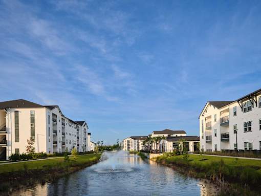A river flows through a residential area with modern buildings on either side.