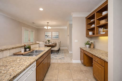 A kitchen with granite countertops and wooden cabinets.