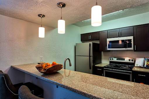 A kitchen with a bowl of fruit on the counter.