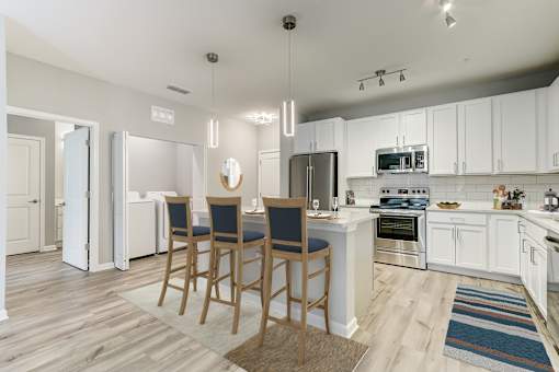 A kitchen with white cabinets and a wooden table.