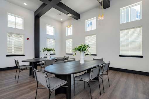 A dining room with a large table and chairs.