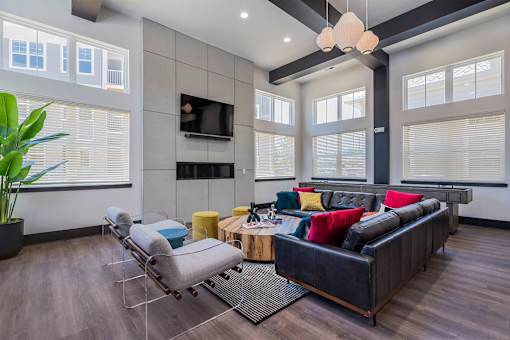 A modern living room with a black couch and a grey chair.
