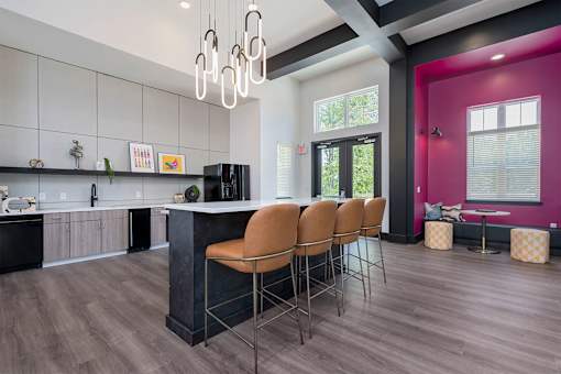 A kitchen with a bar area and chairs.