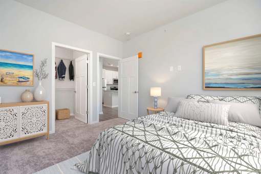 A bedroom with a large bed and a painting on the wall.