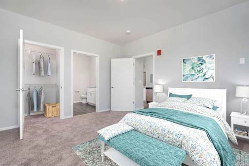 2 Bedroom Luxury Apartments In Jeffersonville, IN - The Laurel - Bedroom With Plush Carpet, Walk-In Closet, Modern Décor, and Attached Bathroom.