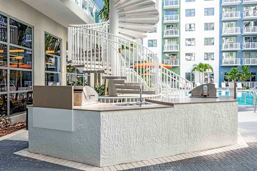 A white staircase with a metal railing is in front of a building.