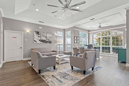 A spacious living room with a grey sofa set and a white coffee table.