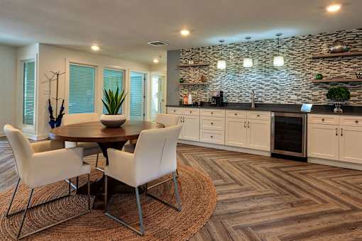A modern dining room with a stone wall and wooden flooring.
