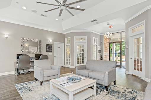 A living room with a white ceiling fan and grey couches.