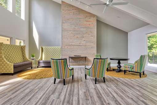 A living room with a brick wall and striped chairs.