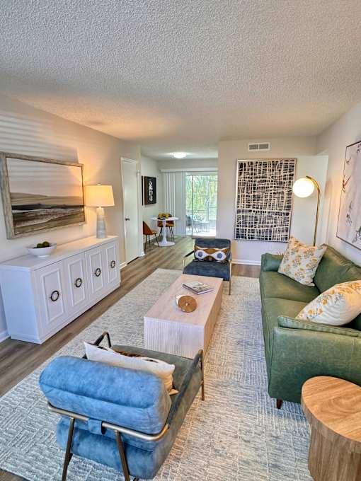 A living room with a green couch and a blue chair.