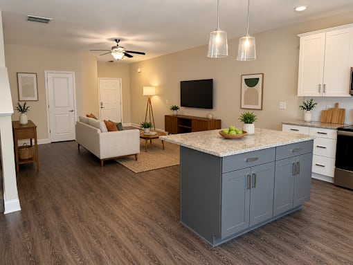 A modern kitchen with a large island and wooden floors.
