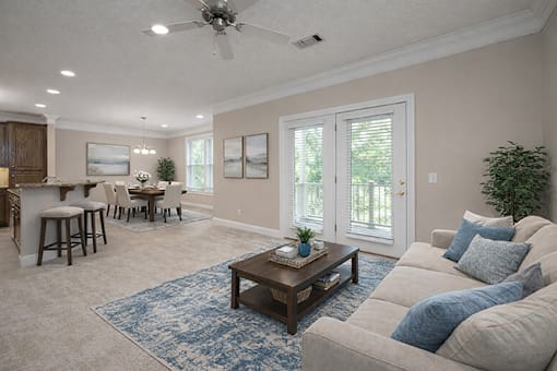 A living room with a beige couch, a wooden coffee table, and a ceiling fan.