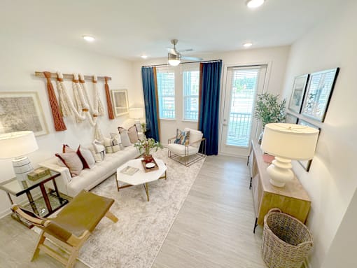 A well-lit living room with a white sofa, a coffee table, and a rug.
