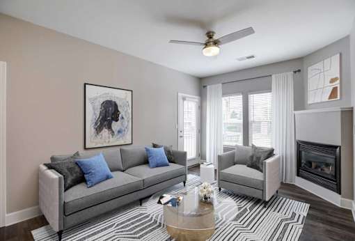 A living room with a grey couch, a coffee table, and a painting on the wall.