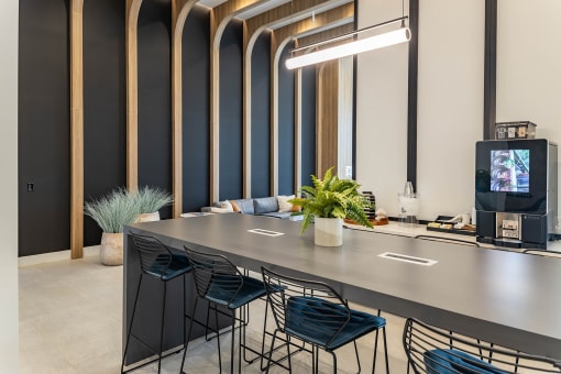 a long table with chairs and a tv in a room with a large mirror at Leena Plantation, Plantation, 33322