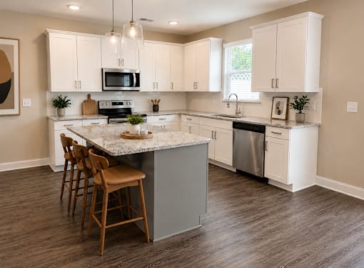 A Kitchen with island with natural stone countertops and bar top sitting