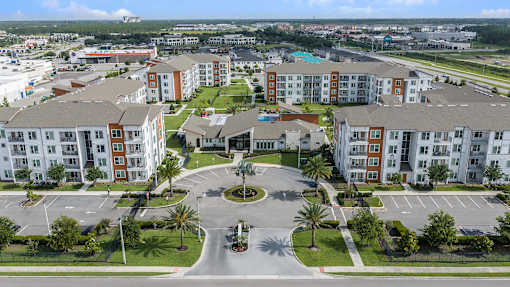 A large apartment complex with a roundabout in the middle of the parking lot.