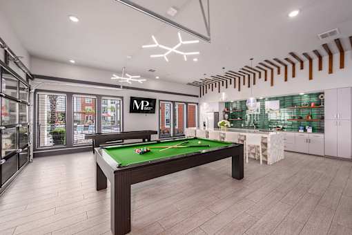 A billiard table is in the middle of a room with a pool table light.