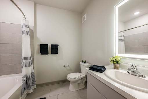 A bathroom with a toilet, sink, and shower.