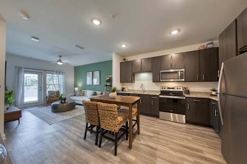 A kitchen with a table and chairs in the middle of the room.