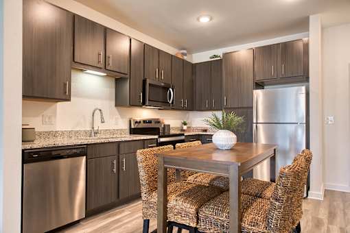 A modern kitchen with a dining table and chairs.