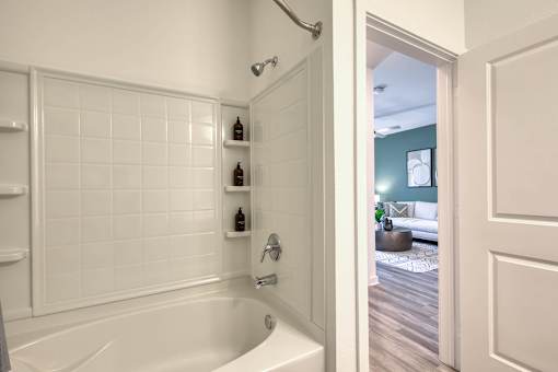 A white bathroom with a white tub and a white door.