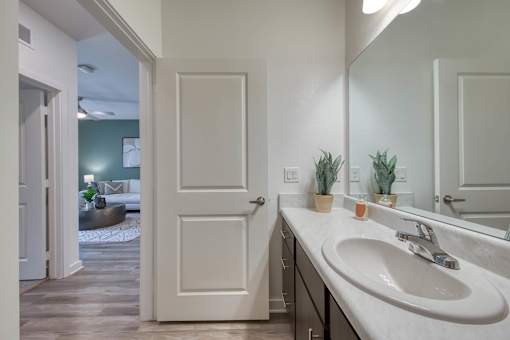 A bathroom with a white sink and a white door.