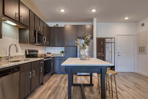 A kitchen with a table and chairs in the middle.